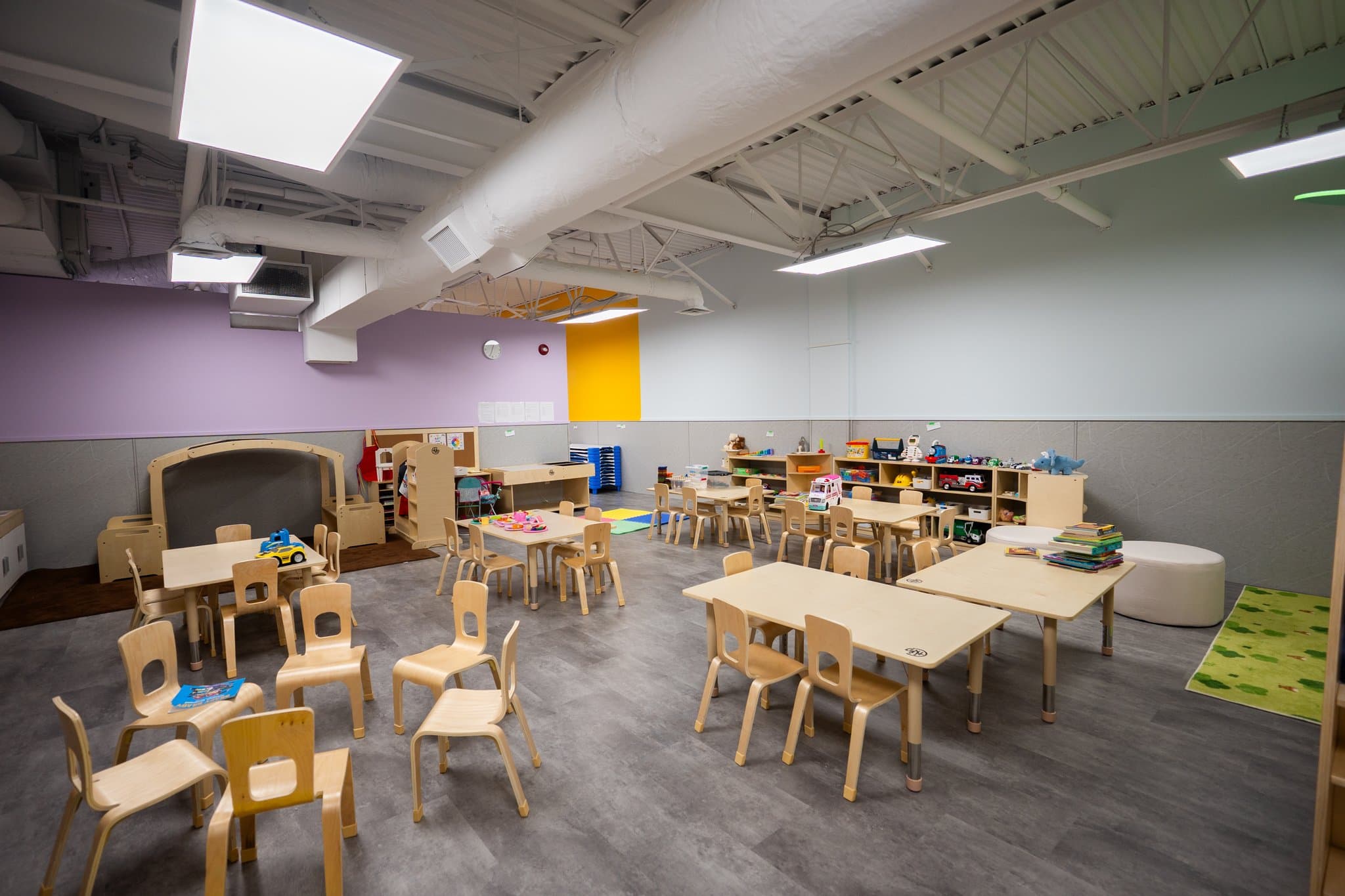 Tiny Genius Daycare bright upstairs preschool classroom with activity tables, learning centers, and natural lighting in Summerside Edmonton
